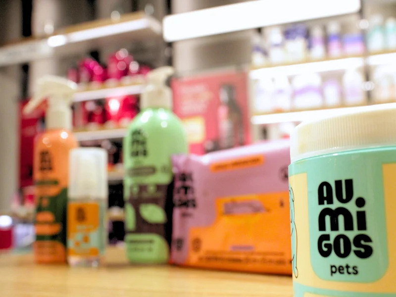 Close-up lateral do pote de dedal dental em primeiro plano, com os demais produtos da linha levemente desfocados ao fundo.