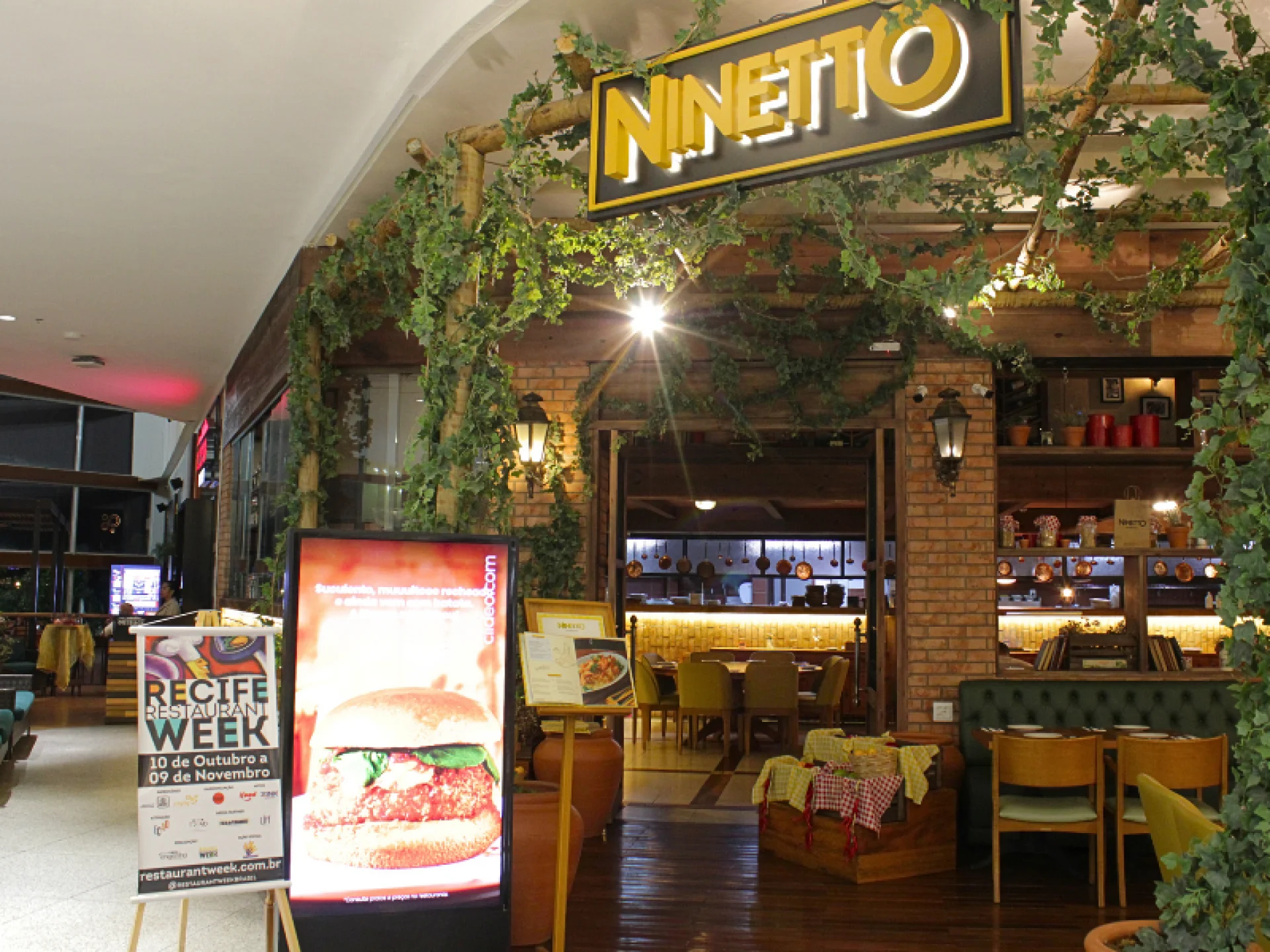 A imagem mostra a fachada da Ninetto Trattoria, com uma placa do Recife Restaurant Week ao lado. A imagem mostra a fachada da Ninetto Trattoria, com uma placa do Recife Restaurant Week ao lado.