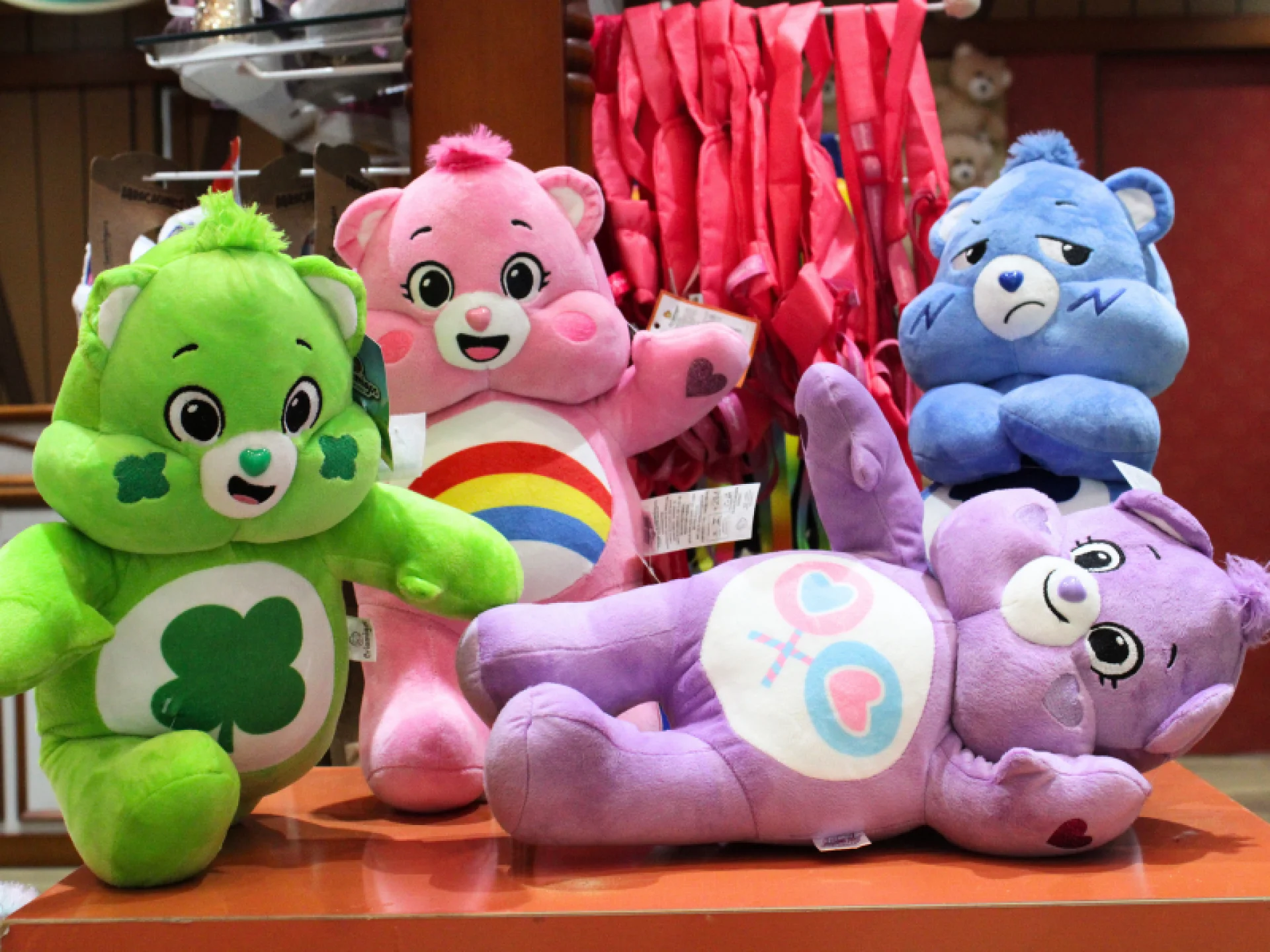 Personagens dos Ursinhos carinhosos dispostos em uma mesa laranja.